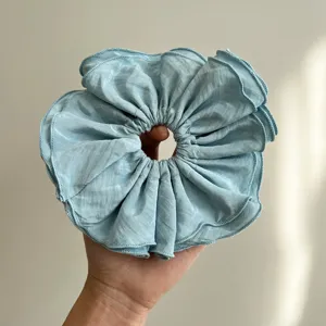 Vista detallada de los volantes de un coletero scrunchie extragrande azul claro