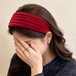 Close-up detail of a red pleated velvet wide headband worn by a model for retro style