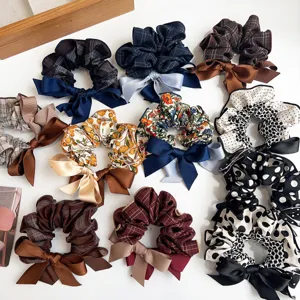 Variety of fabric scrunchies with plaid and polka dot patterns and decorative bows
