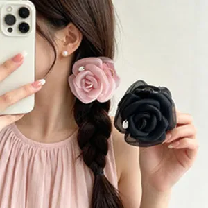 Detail view of an elegant pink mesh rose hair clip worn by a model with a braided hairstyle.