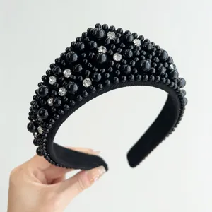 Primo piano di un cerchietto retrò nero con dettagli di perle e strass
