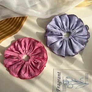 Detalle de los coleteros de tela plisada de cuatro capas extragrandes en rosa y púrpura
