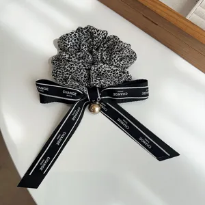 Coletero de leopardo con lazo de cinta Change Paris y detalle de dije dorado elegante