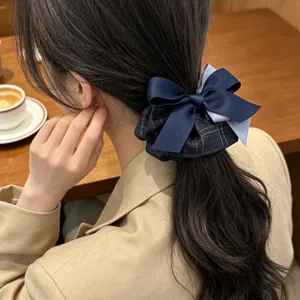 Close-up detail of a Korean style navy blue plaid fabric bow hair scrunchie on a ponytail.