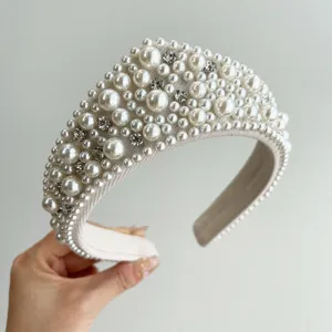 Dettaglio di un elegante cerchietto largo con perle finte e strass scintillanti
