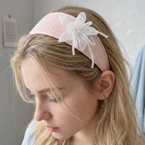 Detail of handmade beaded white flower design on elegant pink wide headband for women