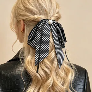 Eleganter schwarz-weiß gestreifter Haarknoten mit Perle, gestylt auf blondem Haar