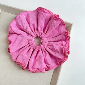 Primer plano detallado del coletero gigante plisado de cuatro capas en color rosa vibrante