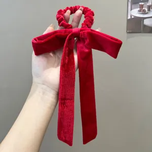 Close-up of an elegant red velvet bow hair tie with long ribbons for hair styling