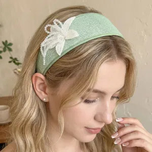Detail of handmade beaded flower on mint green wide woven headband for women's hairstyle