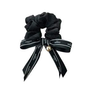 Coletero elegante de lunares negros con lazo de cinta y colgante de perla dorada