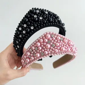 Dettaglio di eleganti cerchietti nero e rosa con perle decorative e cristalli.