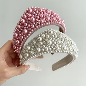 Dettaglio macro di cerchietti imbottiti rosa e bianchi con dense decorazioni di perle