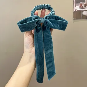 Close-up of elegant blue velvet bow hair scrunchie with long ribbons