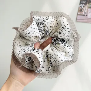 Close-up of a large Korean style floral scrunchie with brown pleated mesh edges