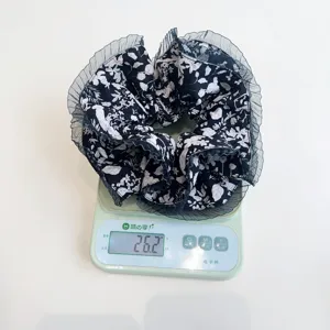 Electronic scale showing the weight measurement of a large floral pleated scrunchie