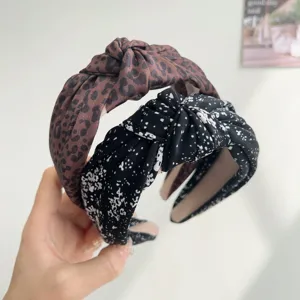 Detail view of wide-brim knotted headbands featuring leopard and ink wash floral patterns