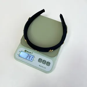 Detail view of black satin padded headband with gold bee charms weighing 34.1 grams