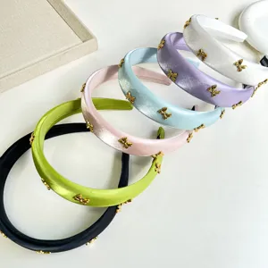 Elegant satin padded headbands with gold bow charms in multiple spring colors