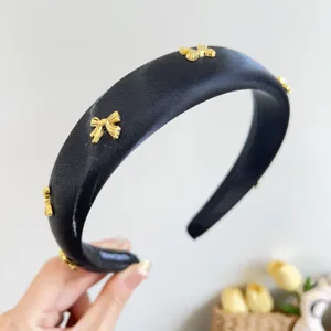 Elegant black satin padded headband with gold bow charms for high volume style