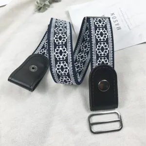 Detail view of elastic buckle-free stretch belt with blue floral lace and black leather ends.