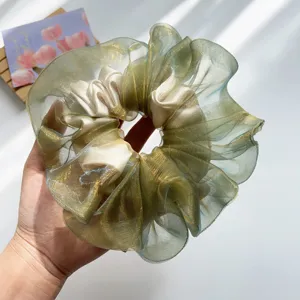 Detailansicht eines schimmernden grünen Organza-Scrunchies mit traumhafter Textur und Satin.