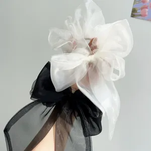 Nahaufnahme eleganter schwarz-weißer Organza-Haargummi-Schleifen mit Textur