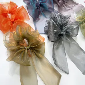 Detailaufnahme von irisierenden Organza-Schleifen-Haargummis in verschiedenen Pastellfarben