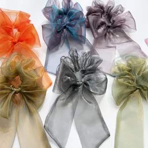 Detailansicht von schimmernden Organza-Haargummis mit Schleife in verschiedenen Farben