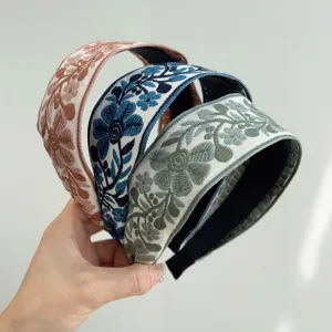 Detailed macro view of embroidered floral patterns on vintage bohemian wide fabric headbands