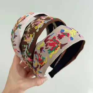 Detailed view of three bohemian embroidered headbands with vintage floral patterns