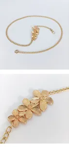 Gold metal waist chain body jewelry with floral charm, elegant design for beach and party.