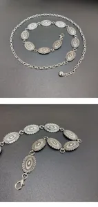 Detailed shot of retro silver metal waist chain with oval carved links for women.