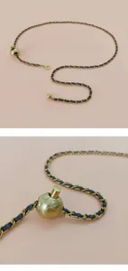 Vue détaillée de la ceinture chaîne en métal entrelacée de cuir avec pendentif flacon parfum.