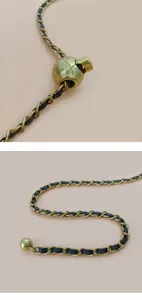 Gros plan sur une chaîne dorée entrelacée de cuir noir avec un charmant détail sphérique.