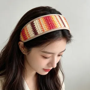 Gros plan d'un large serre-tête en paille tressée colorée porté par un mannequin asiatique