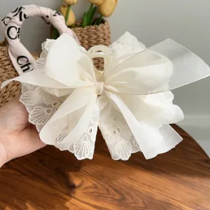 Close-up of an elegant off-white double-layered lace bow hair claw clip for women