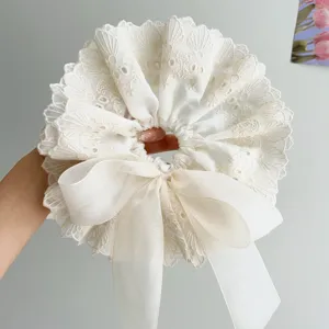 Close-up detail of white double-layer lace scrunchie with an elegant ribbon bow design