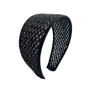 Serre-tête large tressé noir élégant pour volume de cheveux et style de vacances.