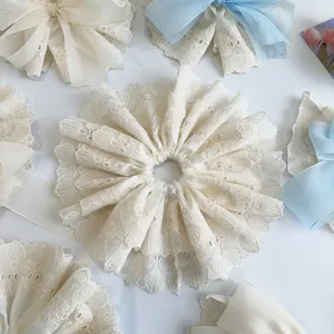 Close-up of elegant double-layered lace bow scrunchies and hair clips in cream and blue