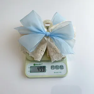 Detailed macro view of a large blue lace bow hair claw clip weighing 49.9g on a mini scale