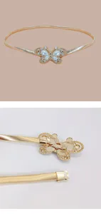 Gold metal spring waist belt detail showing delicate butterfly buckle with pearls and rhinestones.