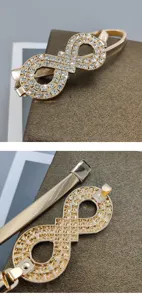 Gold rhinestone infinity buckle elastic waist belt detail, elegant dress accessory.