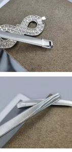 Close-up detail of the shimmering rhinestone buckle and metallic elastic spring belt surface.