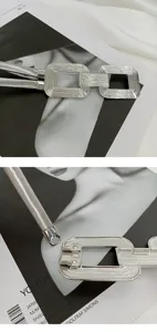 Nahaufnahme eines silbernen elastischen Metallgürtels mit doppelten quadratischen Schnallen.