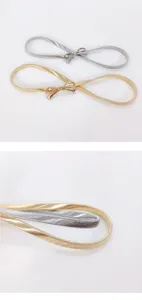 Y2K metal spring waist belt detail showcasing elastic gold and silver bow designs and texture.