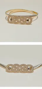Gold metallic elastic waist belt buckle closeup showing detailed rhinestone interlocking rings.