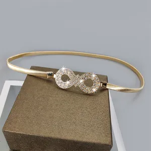 Elegant gold metal elastic waist belt featuring a sparkling rhinestone infinity buckle for dresses.