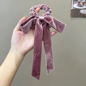 Detailed view of the soft velvet texture and elegant bow design of the hair scrunchie