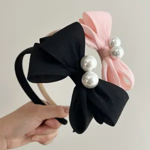 Detailansicht eleganter Haarbänder mit schwarzen und rosa Schleifen und großen Perlen
